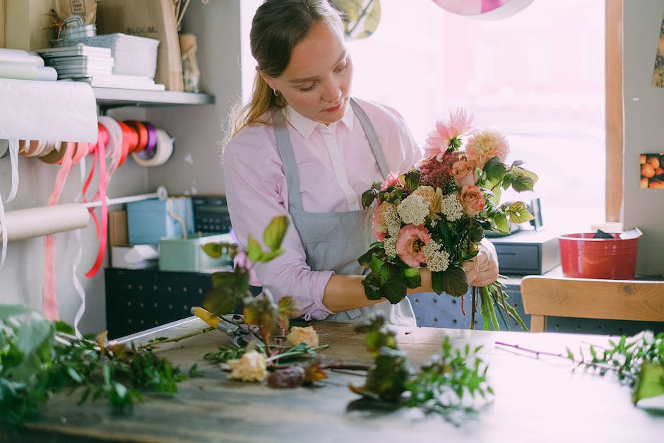 A woman arranging flowers in a beautifully designed room.