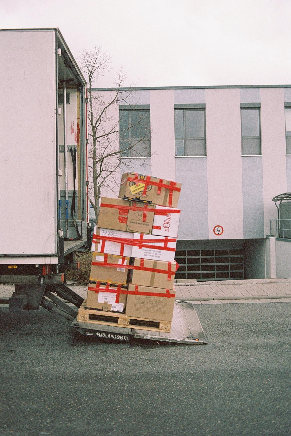 Illustration of a person carrying a stack of moving boxes.