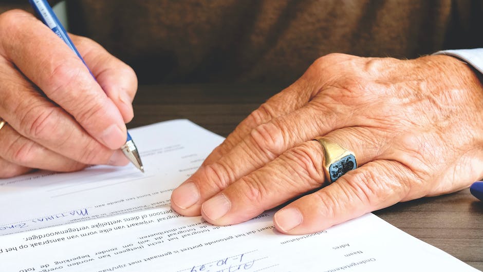 An image showing a person reading and signing a moving contract.