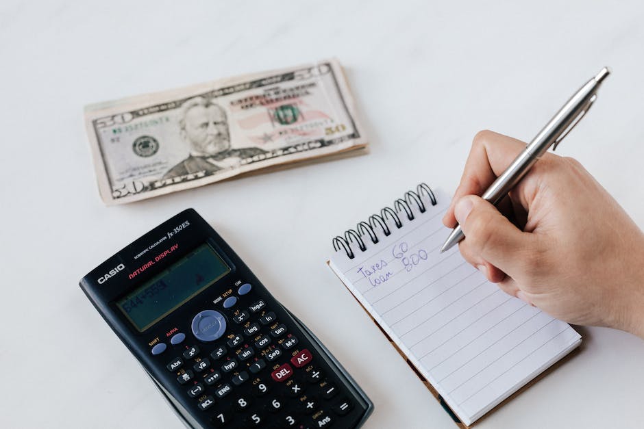 A person holding a pen and writing numbers on a budget sheet, representing the financial aspects of a cross-country relocation.